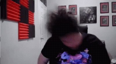 Man With Bun Sitting In Chair By Pictures GIF