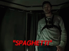 Man With Camera Around Neck In Dark Room With Spaghetti In Red GIF