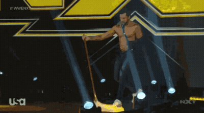 Man With Cane On Stage In Front Of WWE Logo GIF