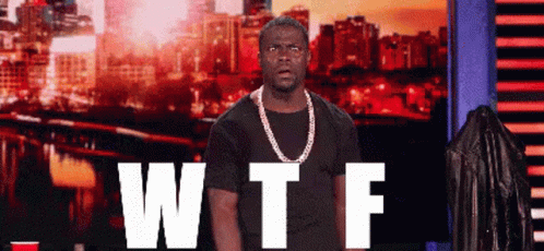 Man With Chain Standing Before WTF Sign GIF