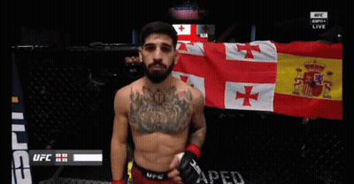 Man With Chest Tattoo In Front Of UFC Banner GIF