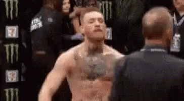 Man With Chest Tattoo Next To Man In Black Suit GIF