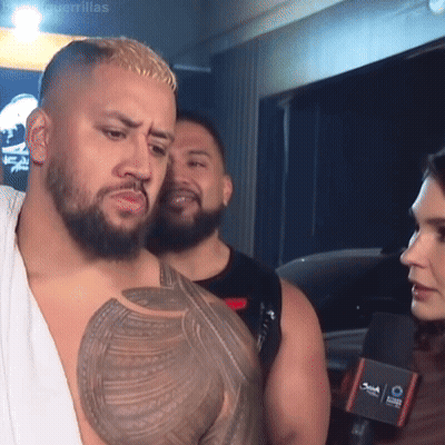 Man With Chest Tattoo Talking To Woman At Microphone GIF
