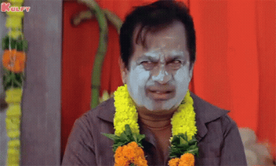 Man With Clay Mask And Flower Garland Making Funny Face GIF