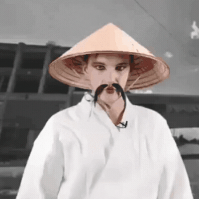 Man With Conical Hat And Mustache In White Robe GIF