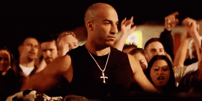 Man With Cross Necklace Standing Before Crowd GIF