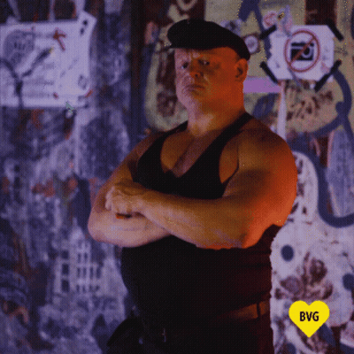 Man With Crossed Arms In Front Of Yellow Heart Saying BG GIF