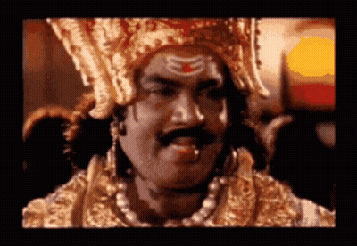 Man With Crown And Mustache Looking At Camera GIF