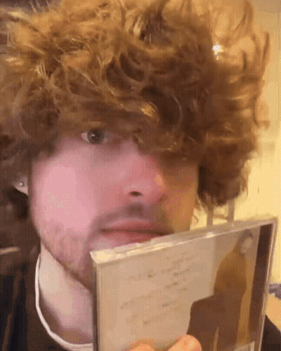 Man With Curly Hair And Beard Holding CD GIF