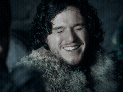 Man With Curly Hair And Beard In Fur Coat Smiles GIF