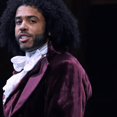 Man With Curly Hair And Beard In Purple Jacket And White Tie GIF
