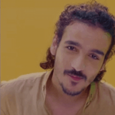 Man With Curly Hair And Beard In Tan Shirt GIF