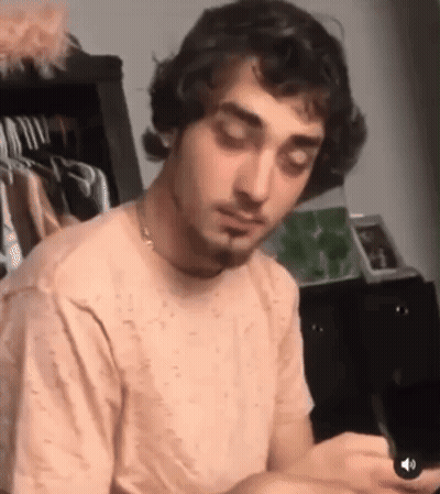 Man With Curly Hair And Beard Looking At Cell Phone GIF