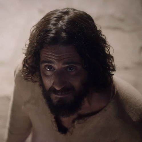 Man With Curly Hair And Beard Looks At Camera GIF