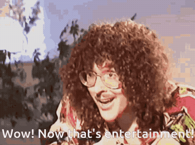Man With Curly Hair And Glasses Says Wow And Now That's Entertainment GIF