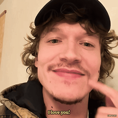Man With Curly Hair And Hat Saying I Love You GIF