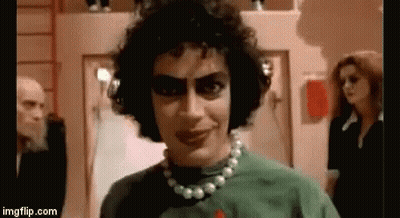 Man With Curly Hair And Pearl Necklace In Green Shirt GIF