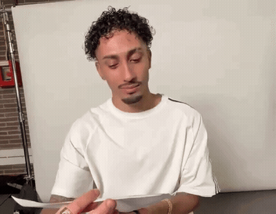 Man With Curly Hair Holding Paper GIF