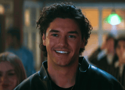 Man With Curly Hair In Black Leather Jacket Smiling GIF