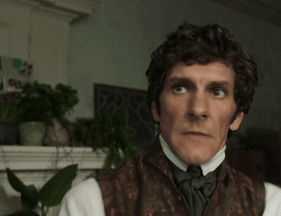 Man With Curly Hair In Brown Vest And Bow Tie GIF