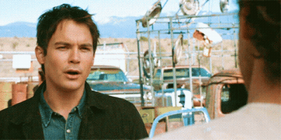 Man With Curly Hair In Front Of Blue Wall GIF