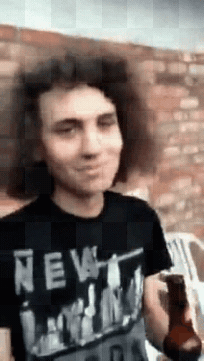 Man With Curly Hair In New York Shirt Holding Beer GIF