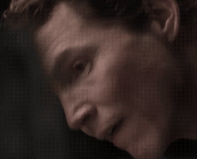 Man With Curly Hair In Plaid Shirt Looking At Camera GIF