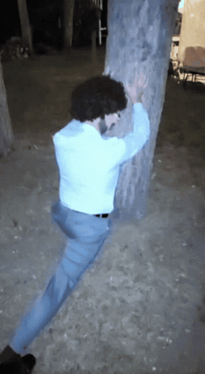 Man With Curly Hair Leaning On Tree GIF