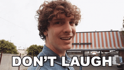 Man With Curly Hair Says Don't Laugh In Front Of Striped Awning GIF