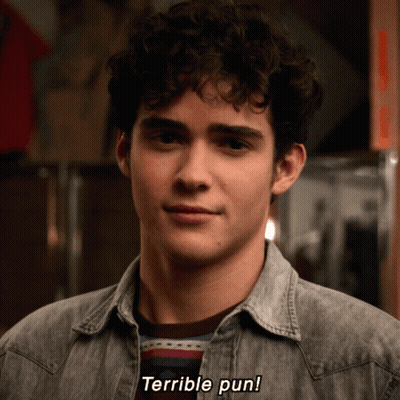 Man With Curly Hair Says Terrible Pun In Denim Shirt GIF