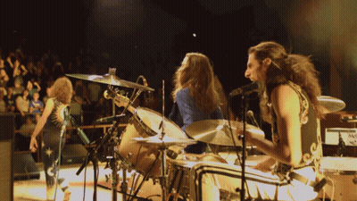 Man With Curly Hair Singing In Blue And Gold Outfit GIF