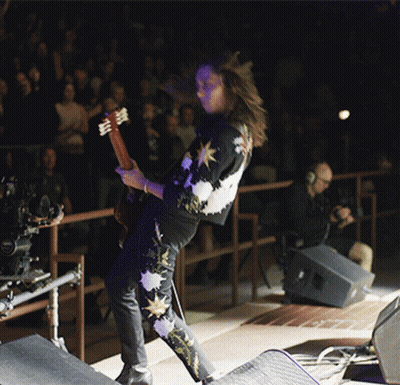 Man With Curly Hair Singing Into Microphone GIF
