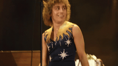 Man With Curly Hair Singing Into Microphone GIF
