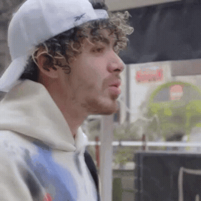 Man With Curly Hair Wearing White Baseball Cap GIF