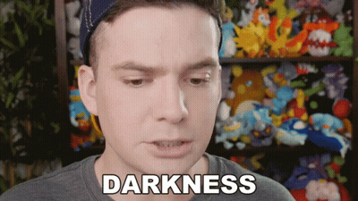 Man With Darkness Word In Front Of Stuffed Animal Shelf GIF