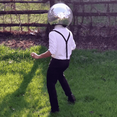 Man With Disco Ball On Head Standing In Grass GIF