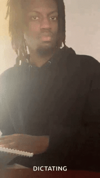Man With Dreadlocks And Beard Dictating Paper GIF