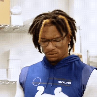 Man With Dreadlocks And Glasses In Colts Hoodie Looking Down GIF
