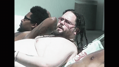 Man With Dreadlocks And Glasses Laying On Beach GIF