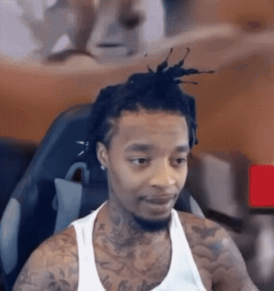Man With Dreadlocks And Tattoos Looking At Camera GIF