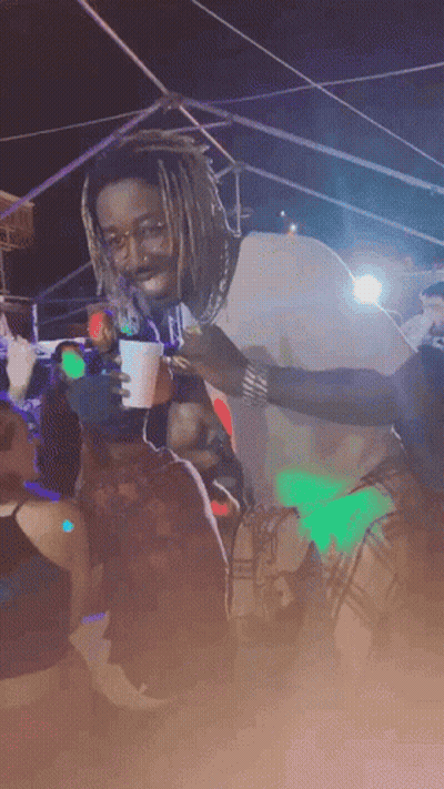Man With Dreadlocks Holding Cup In Crowd GIF