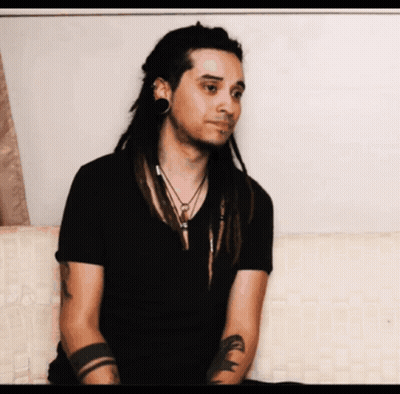 Man With Dreadlocks In Black Shirt And Arm Tattoo GIF