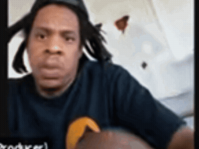 Man With Dreadlocks in Black Shirt With Yellow Circle
