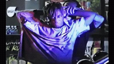 Man With Dreadlocks In Dark Room With Purple Light GIF