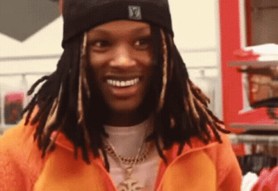 Man With Dreadlocks In Orange Jacket And Black Beanie GIF