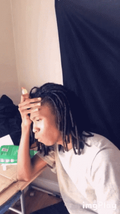 Man With Dreadlocks Sitting At Desk Hand On Head GIF
