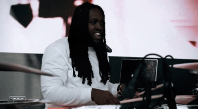 Man With Dreadlocks Sitting At Laptop With Coachella Sign GIF