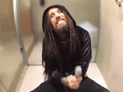 Man With Dreadlocks Sitting On Toilet Making Funny Face GIF
