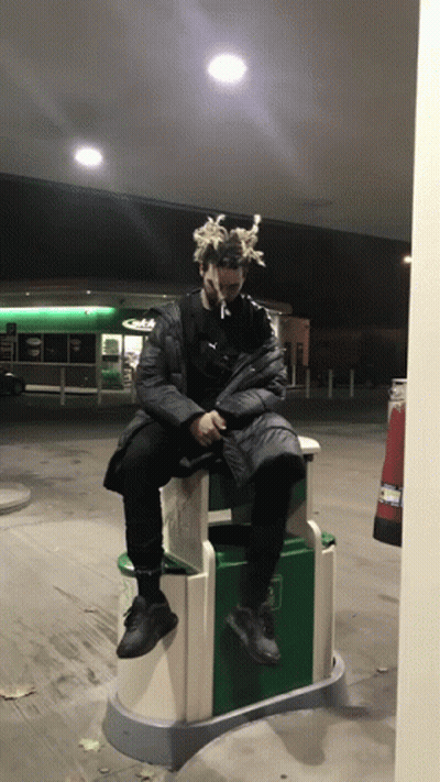 Man With Dreadlocks Sitting On Trash Can GIF