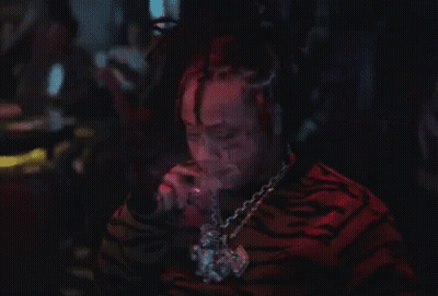 Man With Dreadlocks Smoking Cigarette In Dark Room GIF